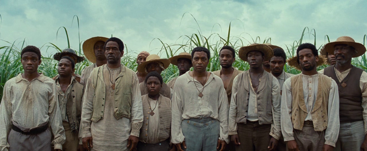 What Is a Period Piece? Definition & Meaning in Film 4 A group of enslaved men stand in front of a sugarcane field