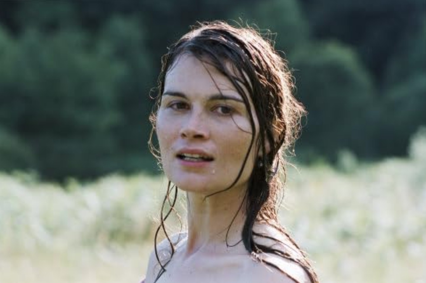 What Is a Period Piece? Definition & Meaning in Film 2 A woman with wet hair looks ahead while standing outdoors in the sun