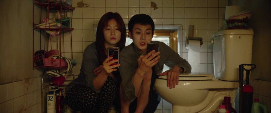 What Does a Movie Critic Do? Job & Career Guide 2 Parasite (2019) still – Kim family crouched in cramped semi-basement bathroom