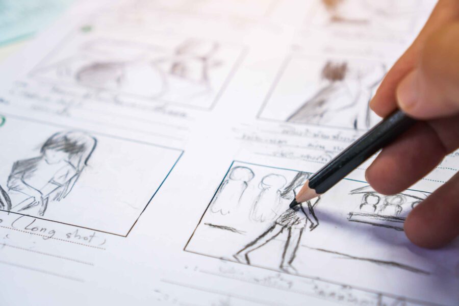 What Is a Storyboard Artist? Job Description & Definition 5 Hand drawing storyboard panels with pencil, showing rough sketches of characters and scenes