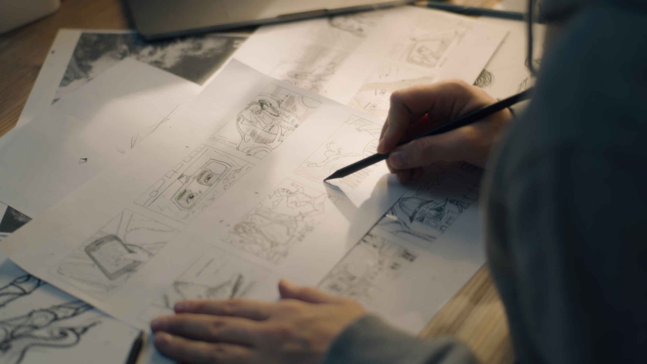 What Is a Storyboard Artist? Job Description & Definition 2 Storyboard artist drawing pencil sketches on multiple sheets of paper in a dimly lit workspace