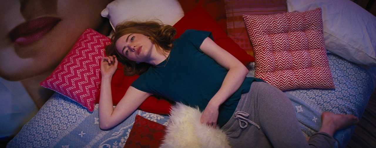 What Does a Set Decorator Do? Duties, Skills, Career Path & How to Start 4 La La Land bedroom set with Emma Stone lying among colorful pillows.