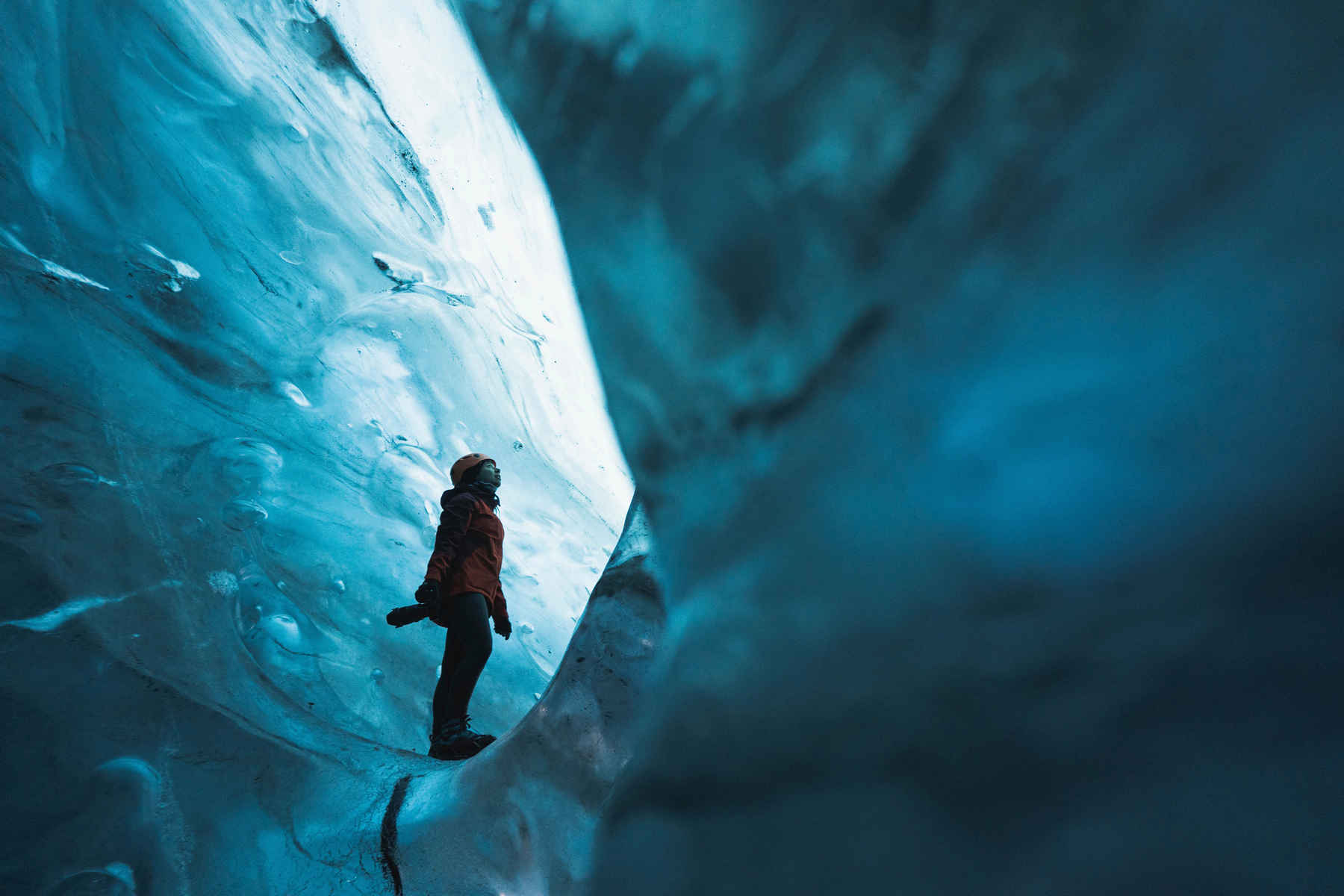 Types of Photography: Genres, Styles & Techniques Explained 2 Person in red jacket standing inside Breiðamerkurjökull ice cave with blue ice walls