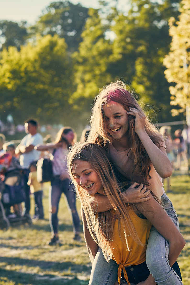 Portrait Photography 101: Definition, Styles & Concepts 5 Two young women laughing together at an outdoor festival.