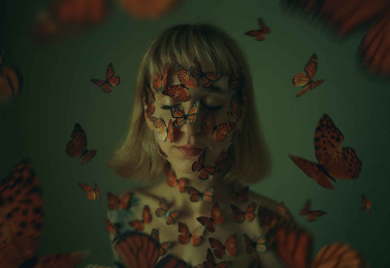 Types of Photography: Genres, Styles & Techniques Explained 22 Woman with closed eyes covered in butterflies, surrounded by butterflies in soft green light