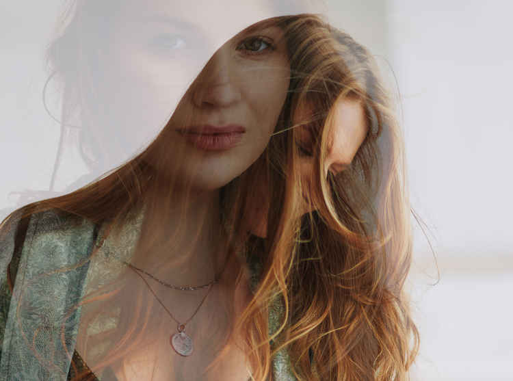 Types of Photography: Genres, Styles & Techniques Explained 28 Double exposure portrait of a woman with overlapping facial expressions and flowing hair