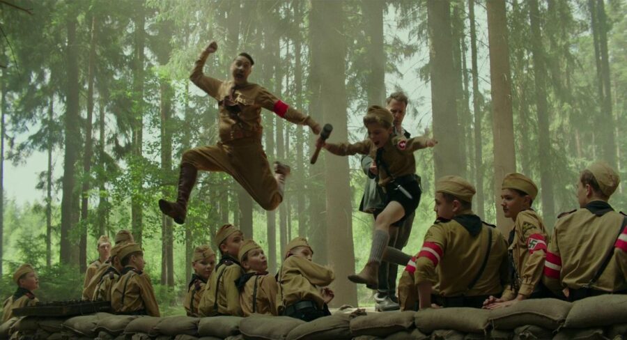 Historical Irony in Film: From Real Events to the Silver Screen 5 Jojo and his imaginary friend Hitler jump at a Nazi youth camp in Jojo Rabbit (2019), revealing the film’s use of satire and historical irony.