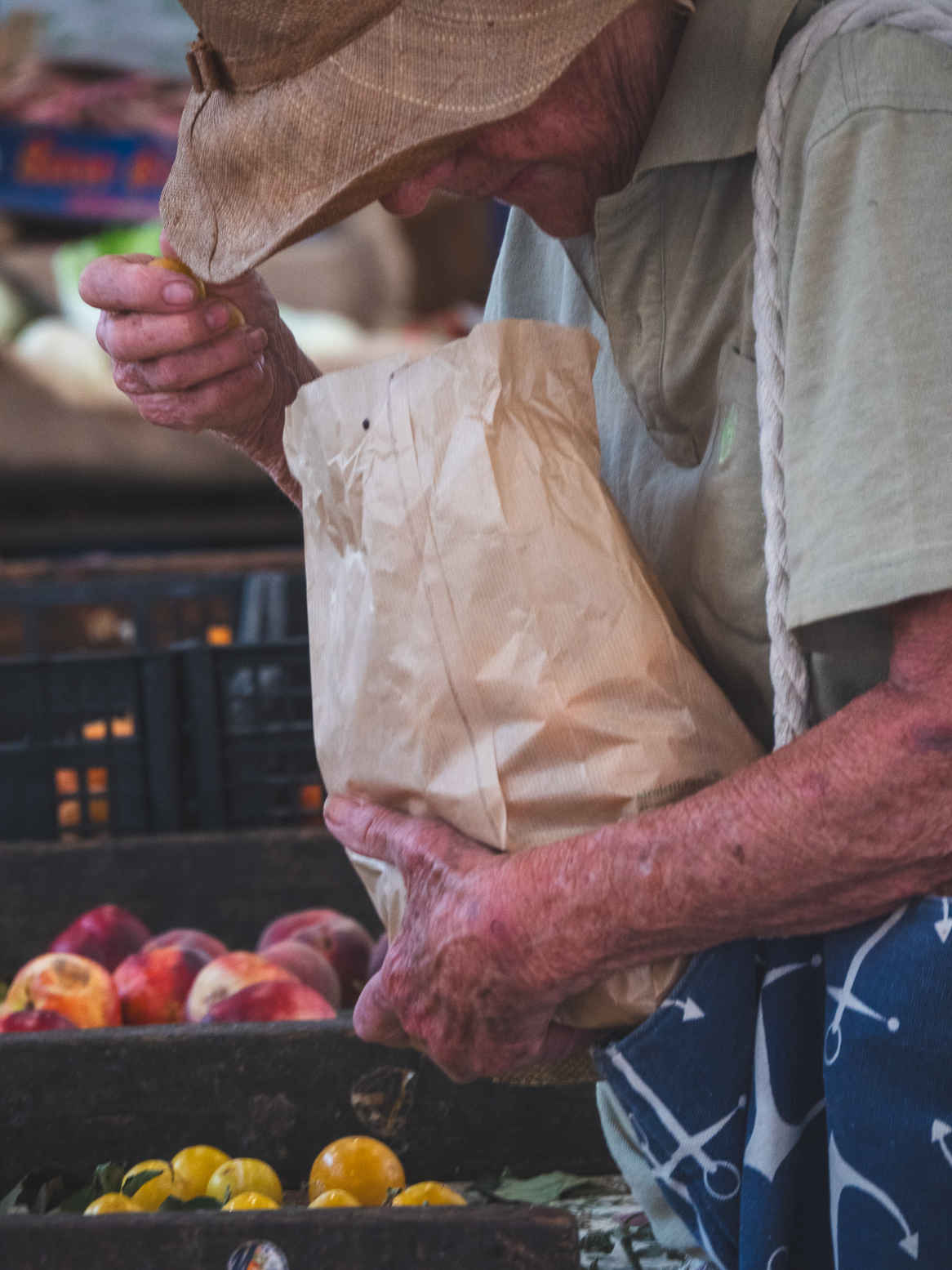 Types of Photography: Genres, Styles & Techniques Explained 17 Elderly woman with a paper bag selecting fruit at a market in La Spezia, Italy