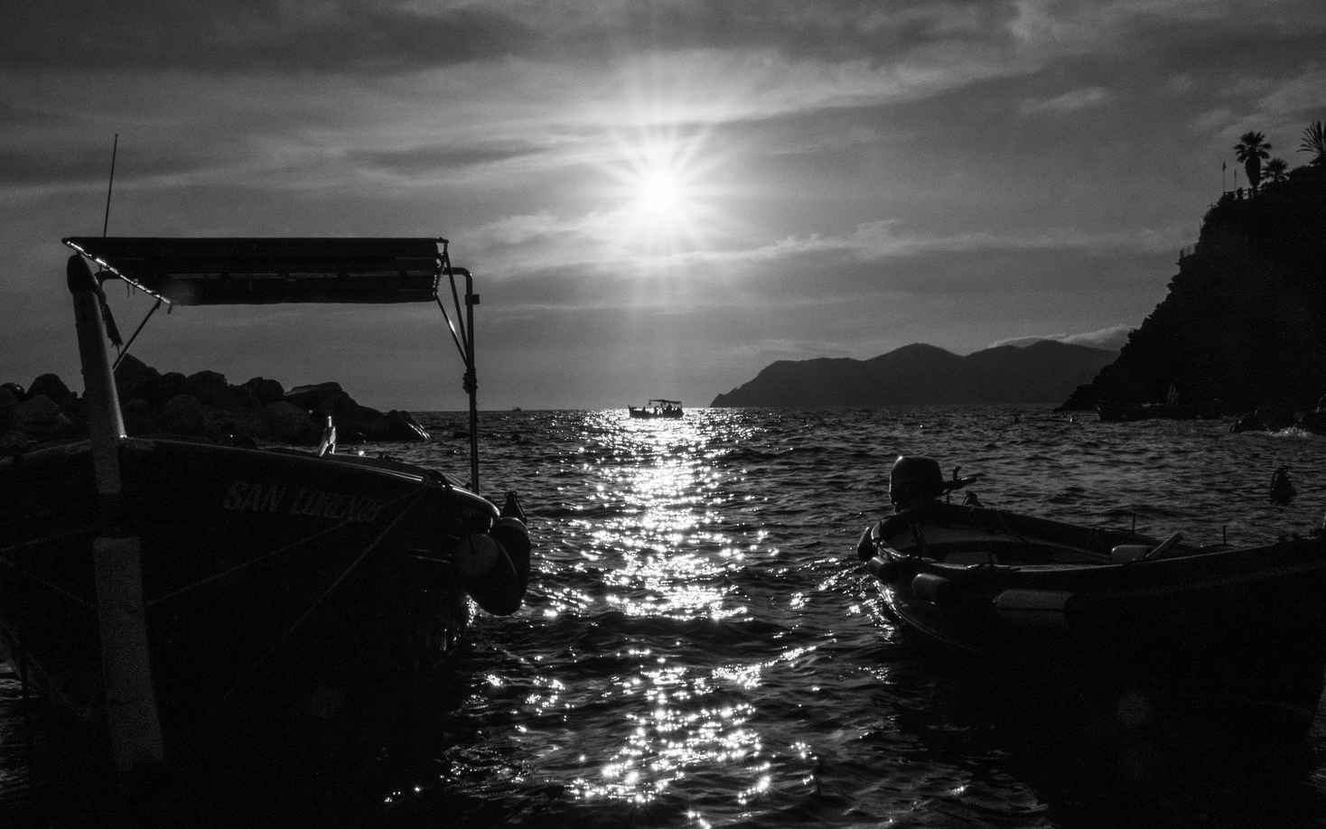 What Is the Exposure Triangle? Aperture, Shutter Speed & ISO Explained 7 Sunset with sunbursts photograph with boats on the sea.