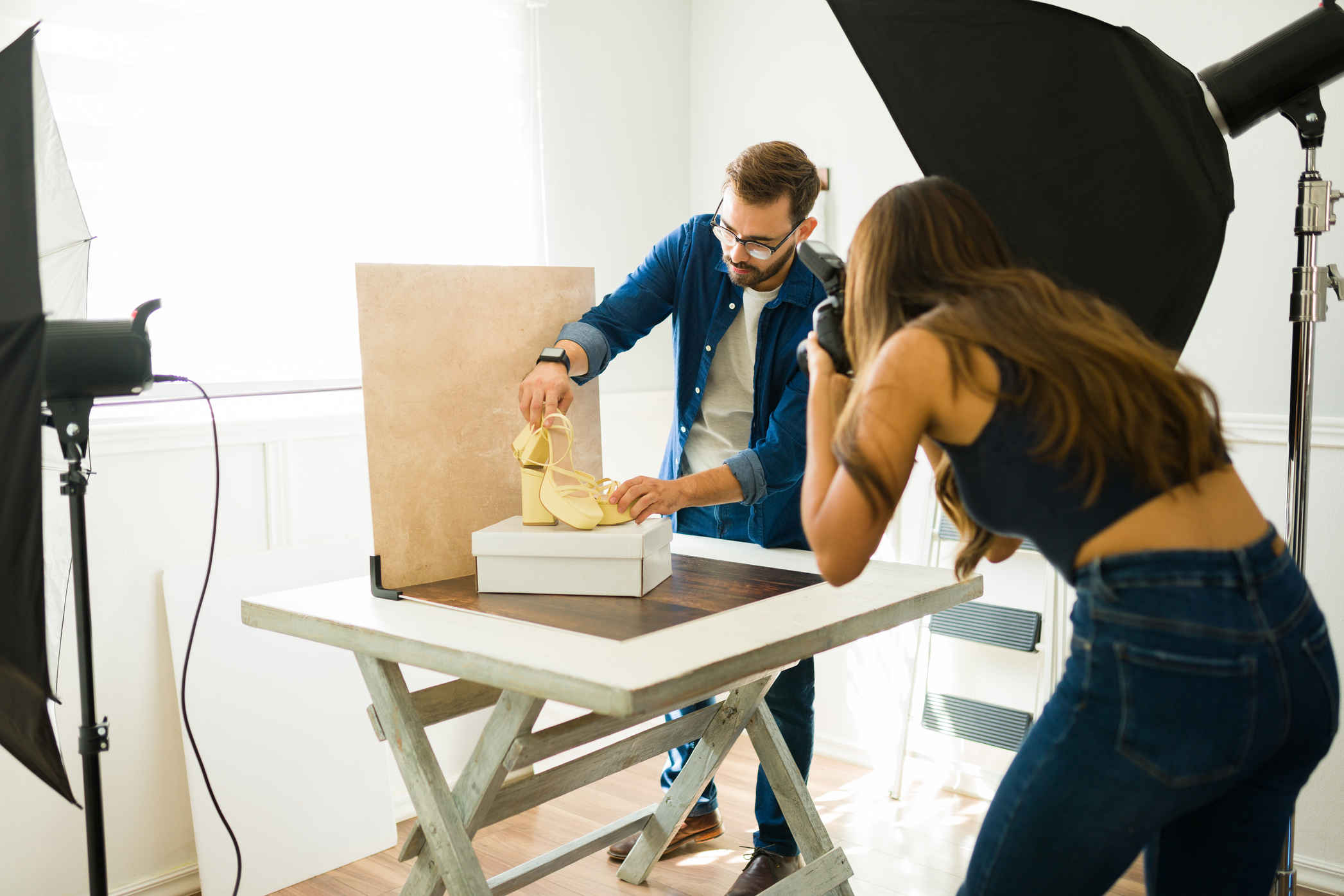 Types of Photography: Genres, Styles & Techniques Explained 13 Photographer capturing yellow shoe on display with studio lights and backdrop