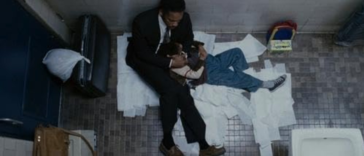 What Is a Memoir? Definition & Examples 2 Will Smith and Jaden Smith sitting on a public restroom floor, surrounded by paper towels, portraying a homeless father and son.