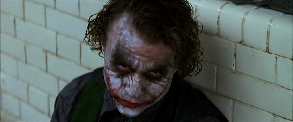 What Is Hypophora? Definition & Film Examples 3 The Joker sits on the floor of an interrogation room, leaning against white subway tiles. His makeup is smeared, and he stares upward with a twisted smile. This is the moment he says, “Do I really look like a guy with a plan?”