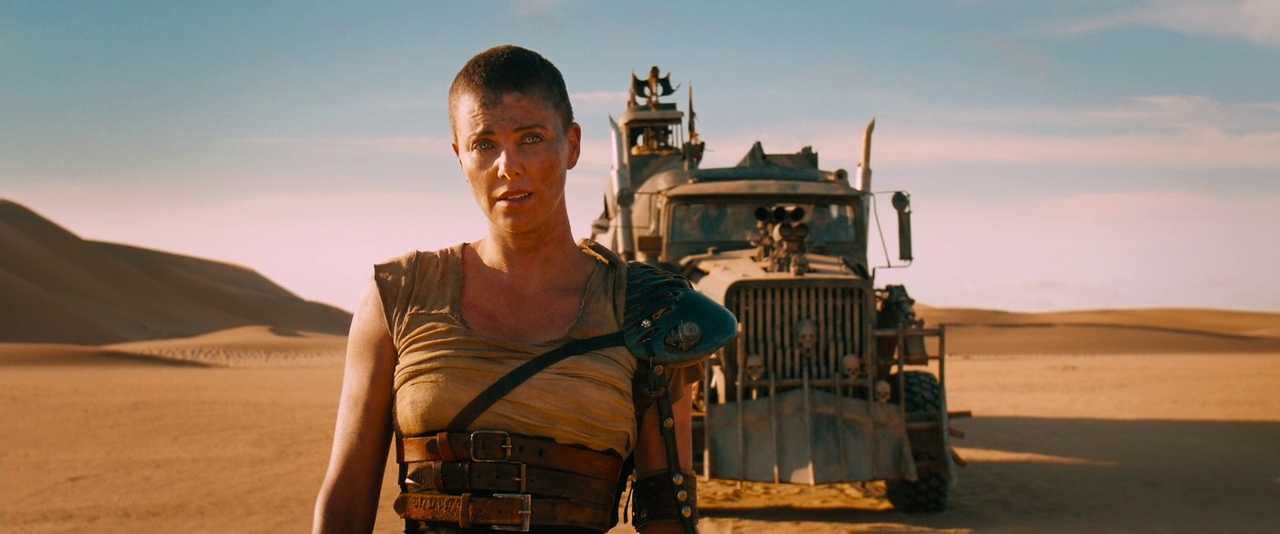 The Damsel in Distress Trope Explored: From Fairy Tales to Modern Movies 6 Furiosa stands in the desert, dusty and determined, with a massive war rig behind her.