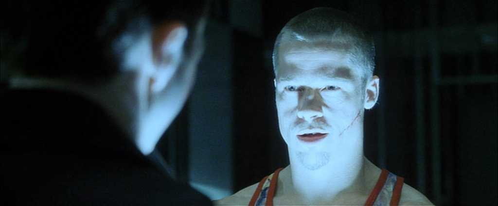 20 Movie Themes for Screenwriters to Explore 16 A bruised man stares intensely under harsh blue lighting, speaking to someone in shadow.