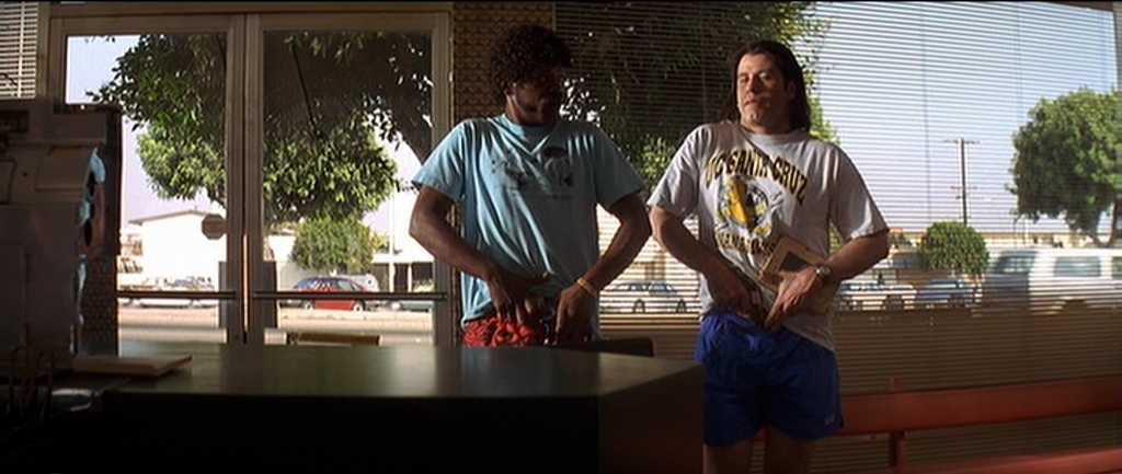 What Is the Difference Between Plot and Story? 2 Jules and Vincent stand in casual clothes near the diner counter, holding books and guns in their waistbands.