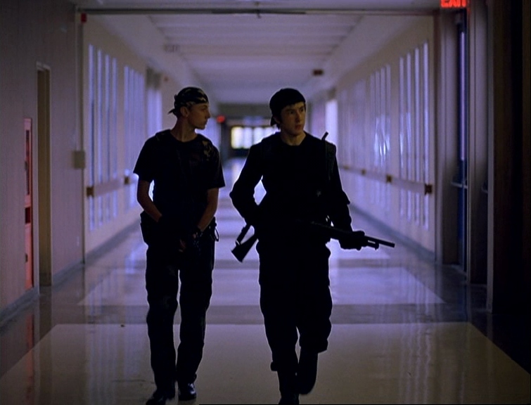 What is the Rashomon Effect? When Stories Conflict in Film 5 Two teenage boys in dark clothing carry rifles as they walk down a long, empty school hallway.