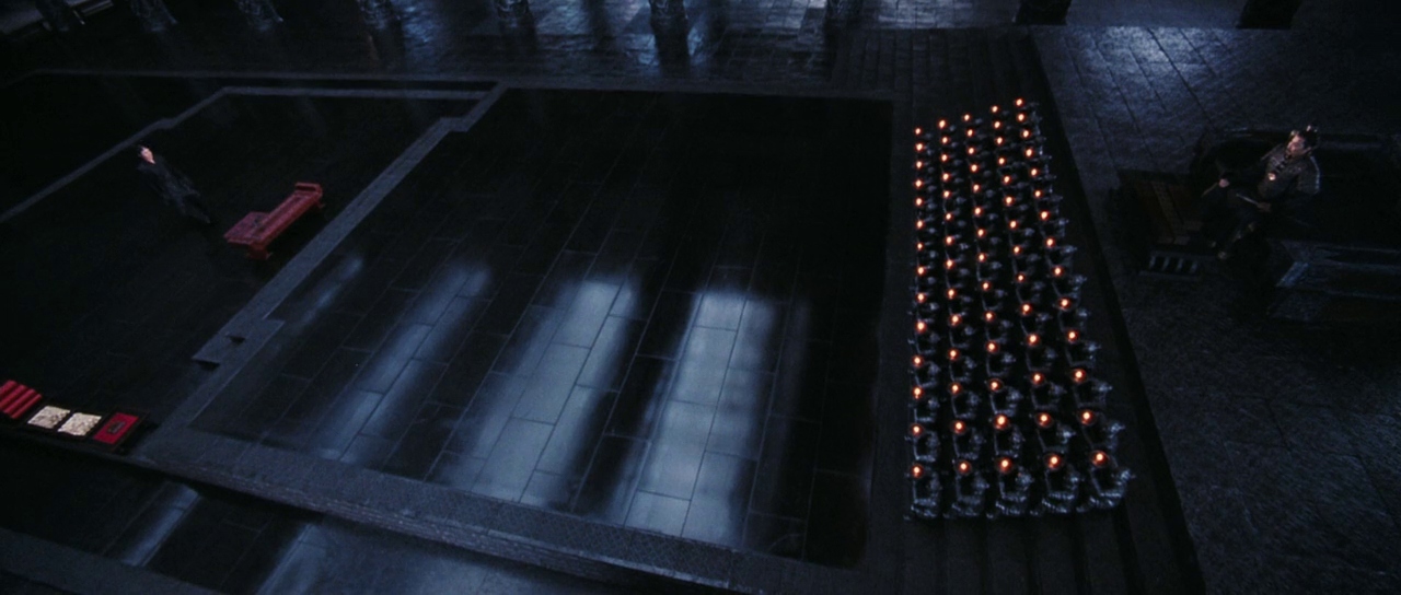 What is the Rashomon Effect? When Stories Conflict in Film 4 Wide shot of Nameless standing before the King of Qin, with rows of candles and guards in a dark, reflective palace interior.