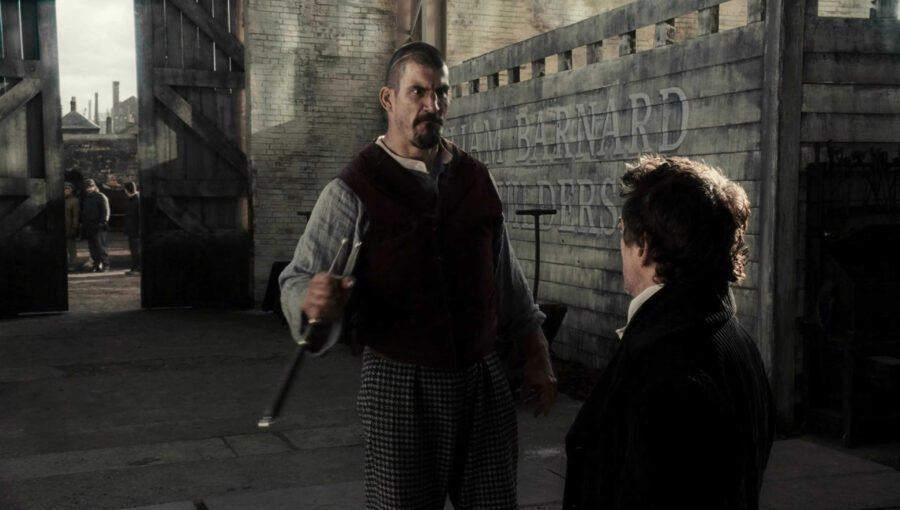 Rising Action in Film: Meaning, Function & Examples 4 A large man holding weapons glares at Sherlock Holmes in a dark industrial yard as workers watch from the background
