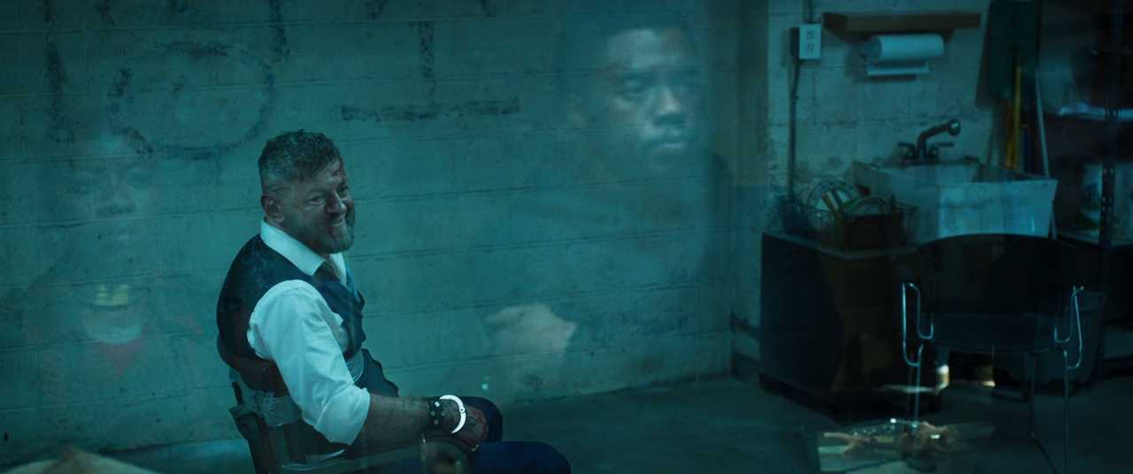 Rising Action in Film: Meaning, Function & Examples 5 A man in a vest is handcuffed to a chair in a dim room as a hologram of T’Challa is projected on the wall behind him