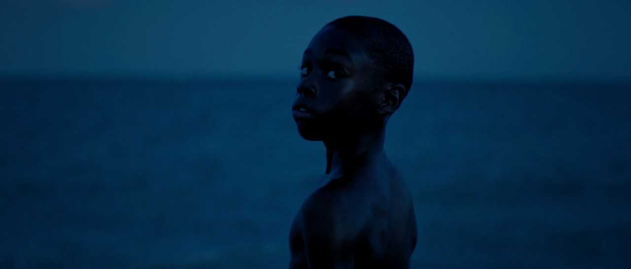 What is Empathy? Definition & Film Examples 2 Young Chiron stands shirtless by the ocean at night, turning to look over his shoulder in deep blue light