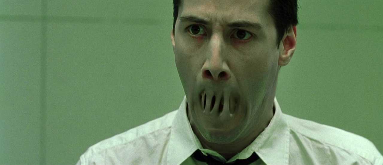 What Is Queer Theory? Definition & Film Examples 6 Neo’s mouth disappears as he tries to speak, looking panicked under harsh green lighting.