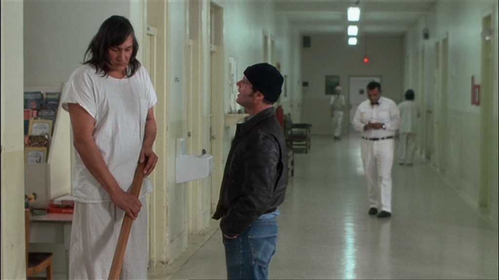Settings Ideas and Examples for Film Scenes 11 Two men speak in a clean, white hallway of a mental hospital with nurses and staff in the background