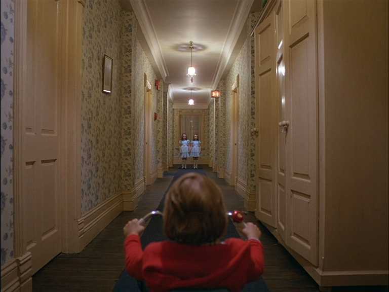 Atmosphere in Film: Definition, Meaning & Examples 4 Boy on tricycle stares down a narrow hallway at two ghostly twin girls standing side by side