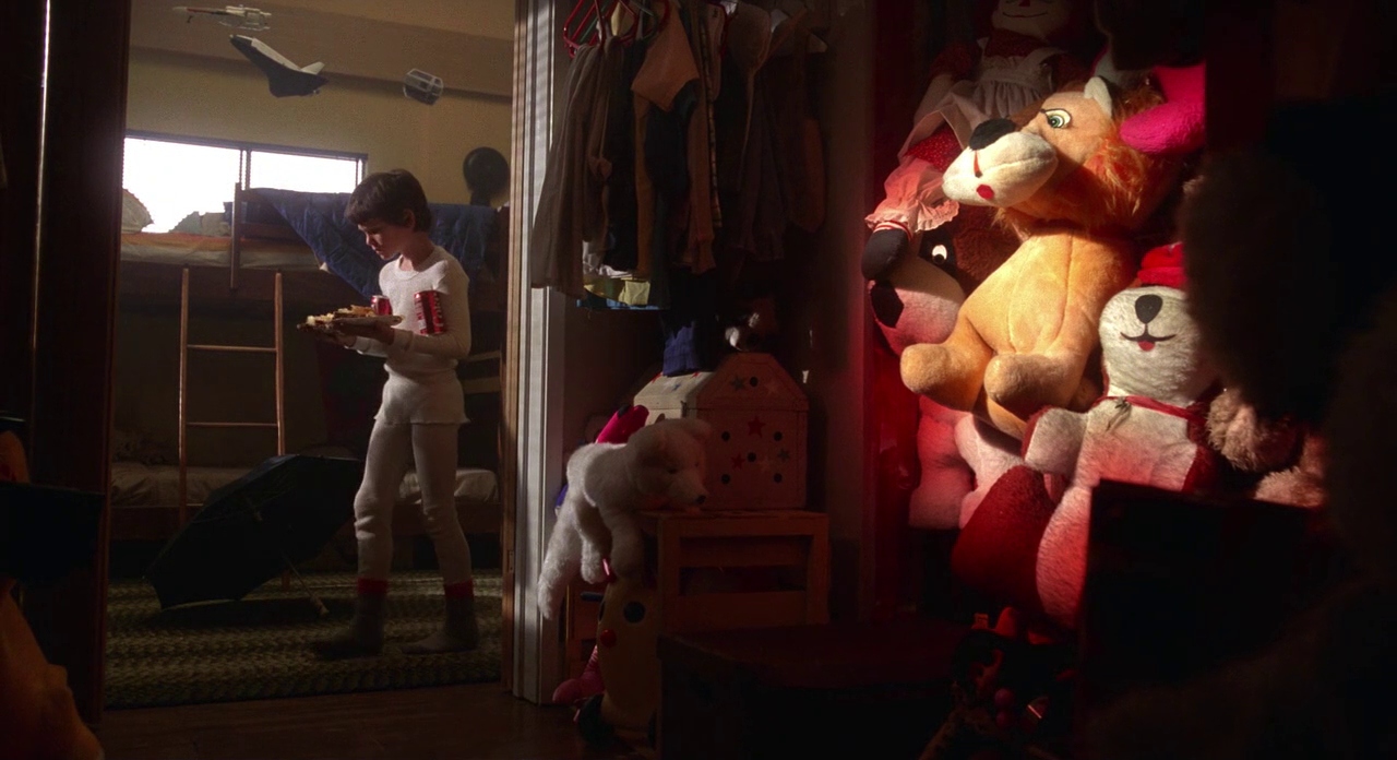 Settings Ideas and Examples for Film Scenes 7 A young boy holding food walks past a cluttered closet filled with stuffed animals where E.T. is hidden