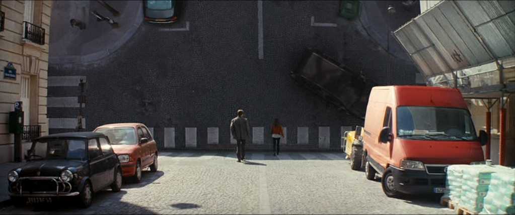 What Is CGI in Film? Definition, History +Examples 7 Two people walk down a street as the road ahead folds upward into the sky, creating a surreal 90-degree cityscape