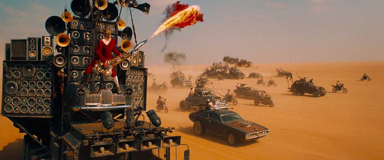 What Is a Color Scheme? Definition & Uses Explained 9 A flame-throwing guitarist stands atop a speaker-covered truck as a fleet of battle vehicles speeds through the desert under an orange-and-blue sky.