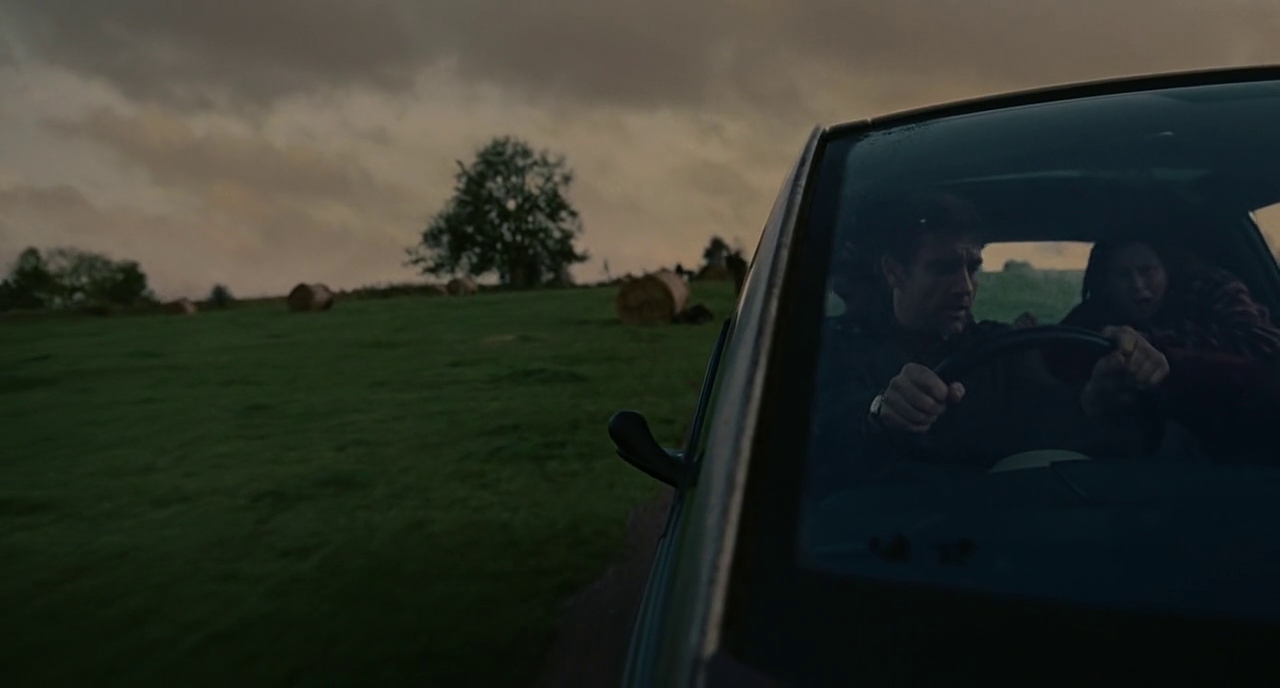 Atmosphere in Film: Definition, Meaning & Examples 6 Tightly framed shot shows man and woman inside a car with only half the vehicle visible, surrounded by an open grassy field