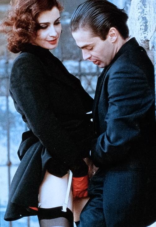What Is Italian Exploitation Cinema? From Sex to Cannibalism 6 A woman in lingerie smiles as a man in a black suit embraces her against a stone wall