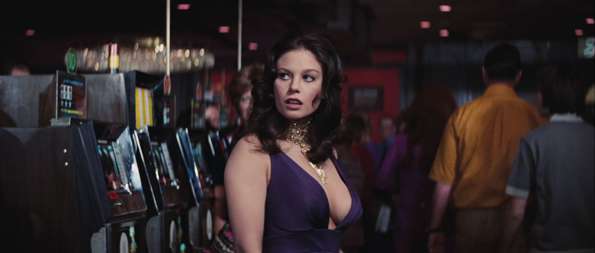What Is the Male Gaze in Film? Definition +How Movies Use It 4 Lana Wood in a purple dress walking past slot machines in a casino, shot with a focus on her chest and expression
