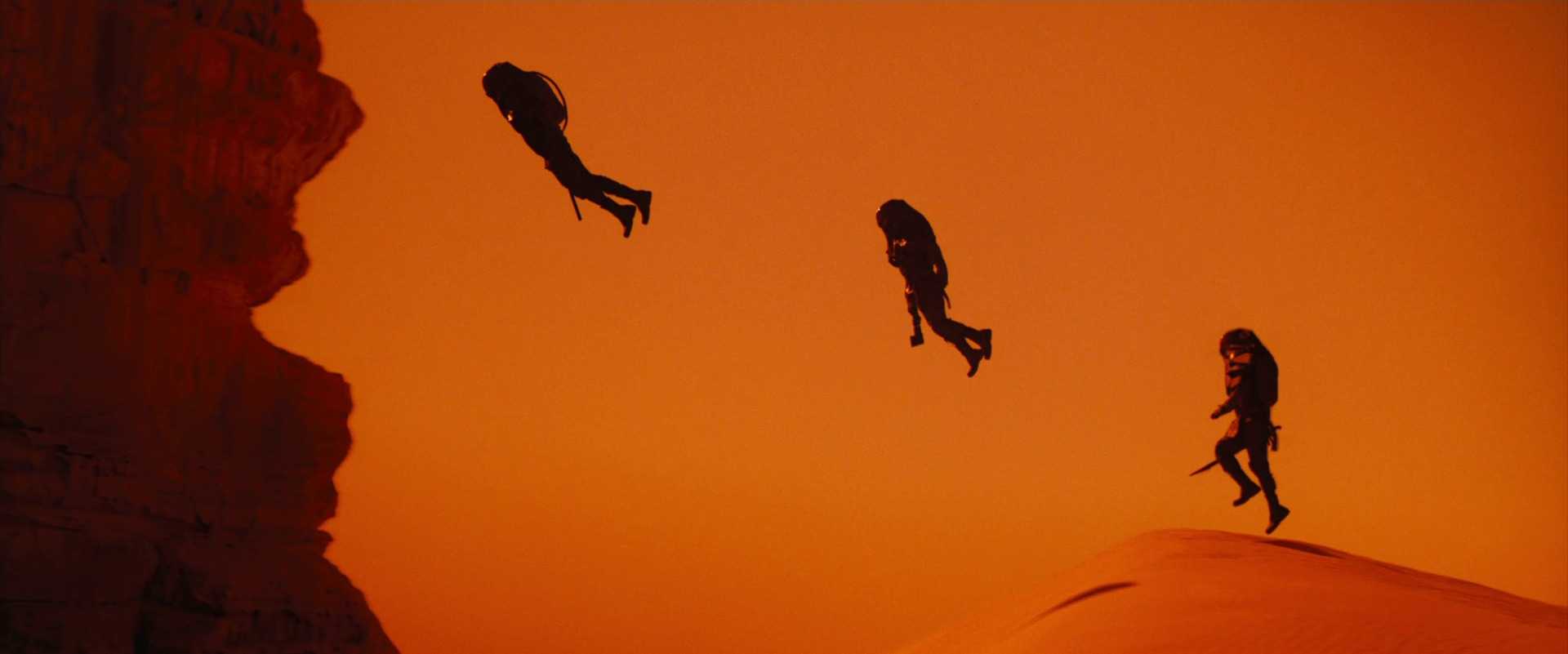 What Is an Analogous Color Scheme? Definition & Film Examples 9 Orange desert landscape with silhouetted figures leaping through the air. Background and foreground share similar warm tones.