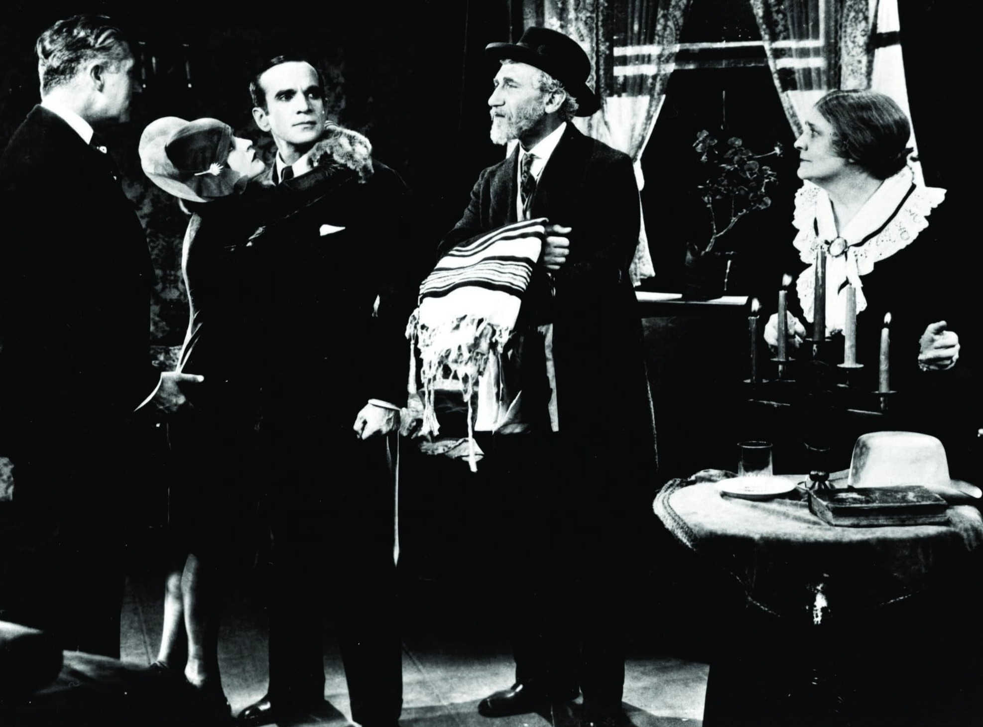 What and When Was the Golden Age of Hollywood? 2 A dramatic black-and-white interior scene with five characters in formal 1920s attire, including a man holding a prayer shawl and Al Jolson looking defiant in the center.