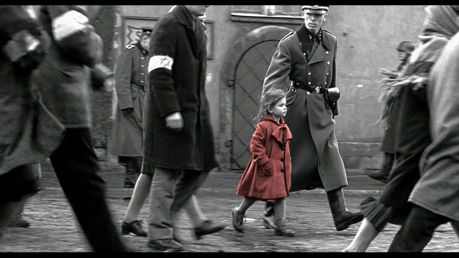 What Is a Focal Point in Art? Definition and Film Use 3 A black-and-white scene of people walking, with a young girl in a red coat standing out among the crowd.