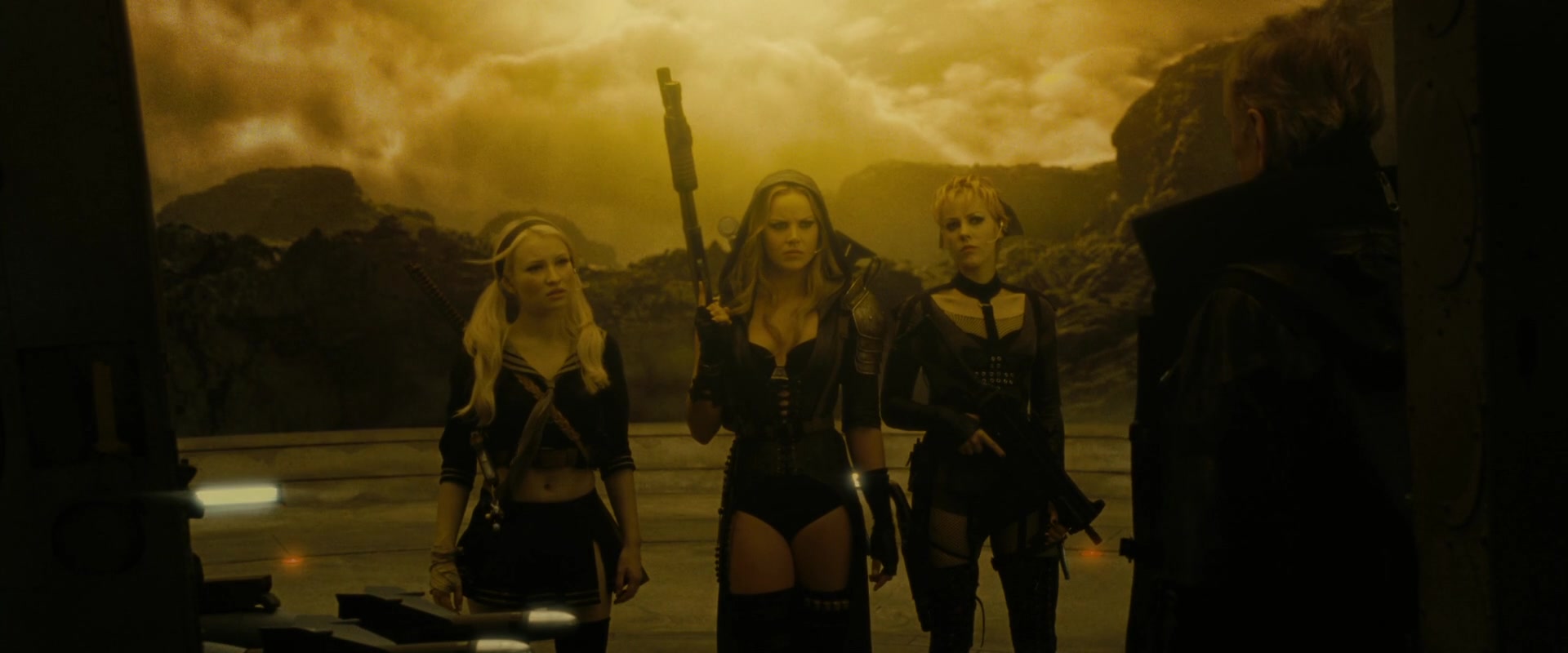 What Is the Male Gaze in Film? Definition +How Movies Use It 3 Three women in revealing combat outfits holding weapons in a yellow-tinted fantasy environment, facing a man in the foreground