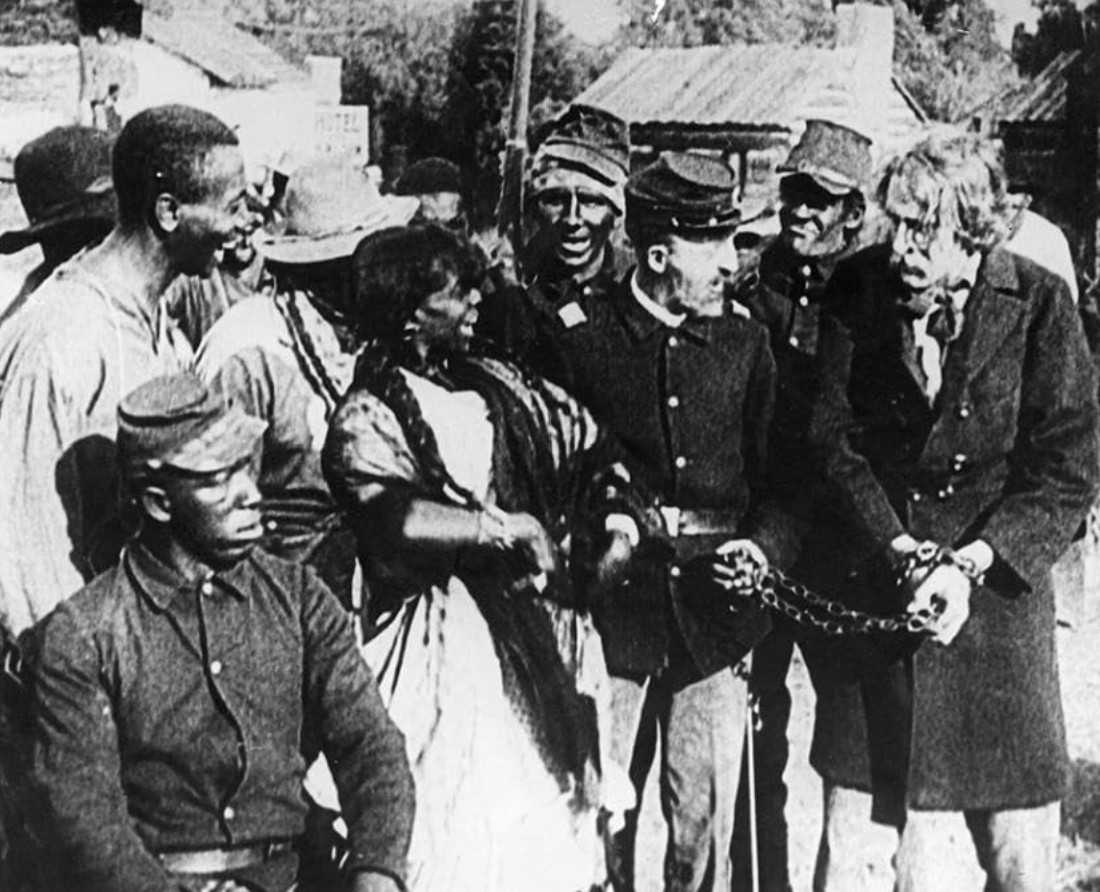 What and When Was the Golden Age of Hollywood? 3 A group of Union soldiers and freed Black Americans watch a captured white man in chains during a dramatic outdoor scene from a Civil War-era film.