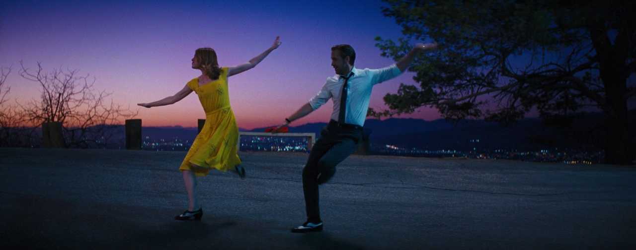 What Is a Complementary Color Scheme? (With Film Examples) 3 Two characters dancing at sunset, with one wearing a yellow dress against a blue and purple sky