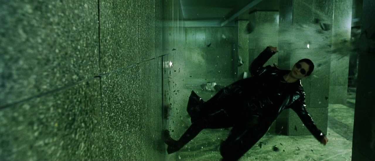 What Is a Monochromatic Color Scheme? Definition & Film Examples 4 Scene from The Matrix with Neo falling sideways in a green-lit hallway as debris explodes around him, showing a strong green monochromatic palette