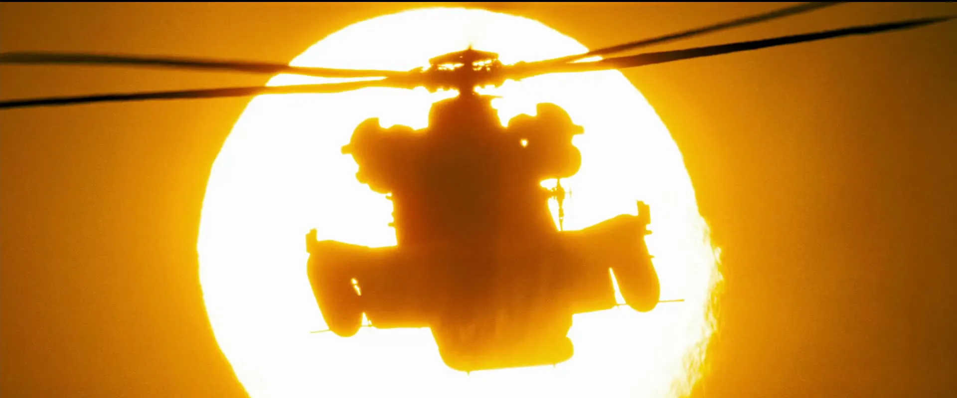 What Is Bayhem? Understand Michael Bay’s Directing Style 2 Helicopter silhouetted against a bright orange sun in the desert during sunset