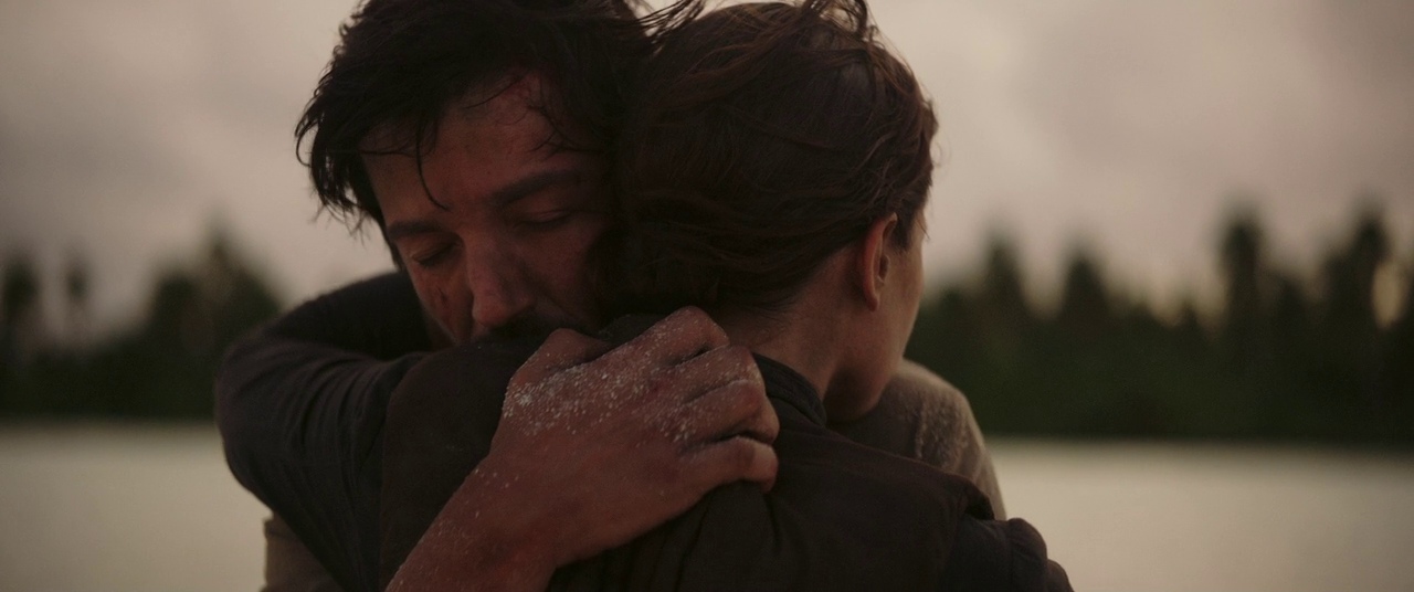 What Is a Spin-Off? Definition & Iconic Examples 6 Cassian Andor and Jyn Erso embracing on a beach in the final moments before destruction in Rogue One