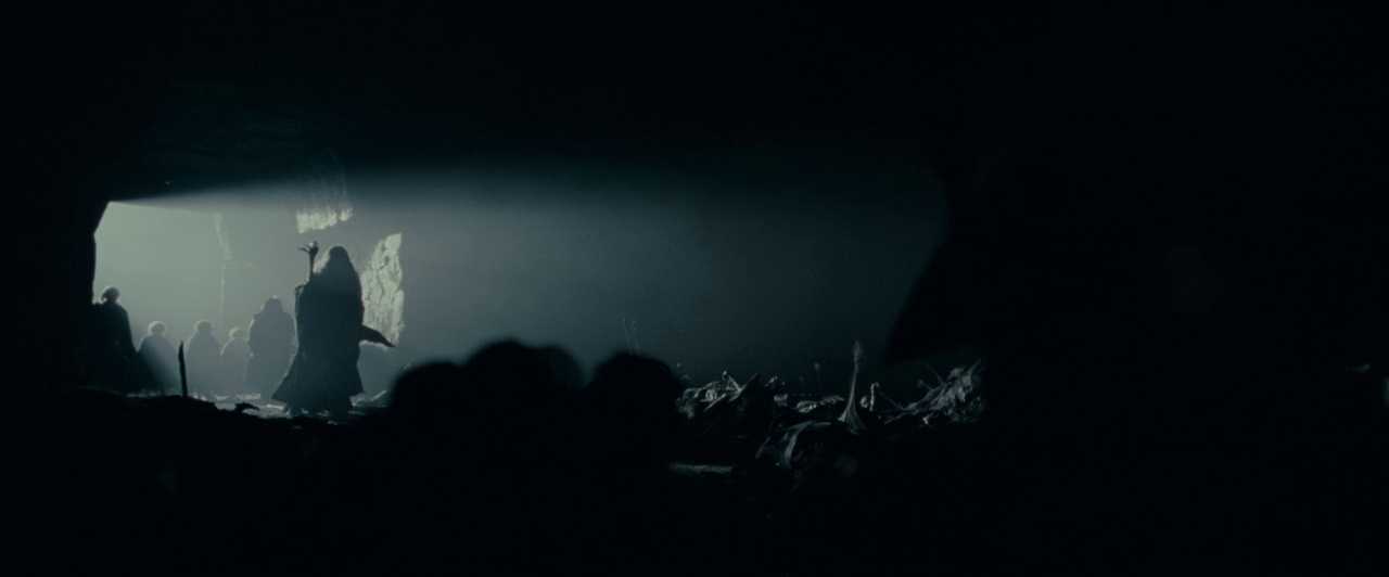 The Fellowship enters the Mines of Moria The Fellowship of the Ring enters the dark Mines of Moria, silhouetted figures walking into a vast cave lit by a narrow opening.