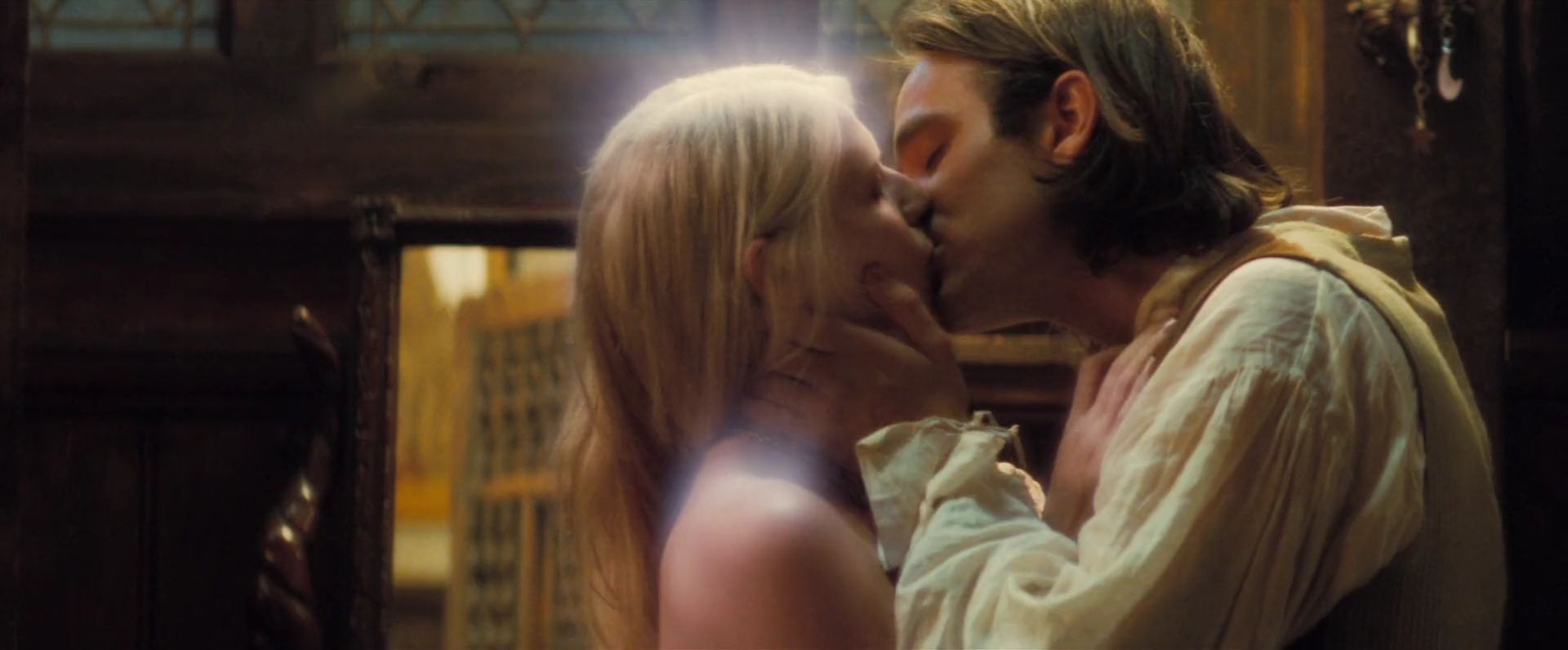 What is a Legend? Definition, Meaning, and Film Examples 3 A blonde woman and a brown-haired man kiss in a warmly lit room, with the man holding her face in his hands.