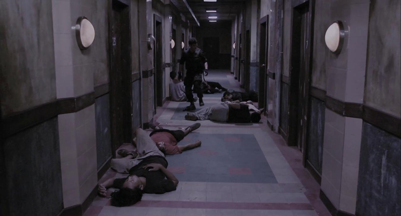 What is an Action Movie? Definition, Conventions, and Writing Tips 8 A narrow apartment hallway filled with unconscious bodies after a brutal close-quarters fight, as a lone fighter moves forward.