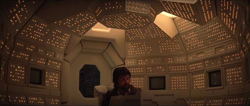 Genre Theory in Film: How Genres Organize Expectation and Meaning 2 Captain Dallas (Tom Skerritt) sits at a control console in a white, angular spaceship room covered in small blinking lights and panel grids.