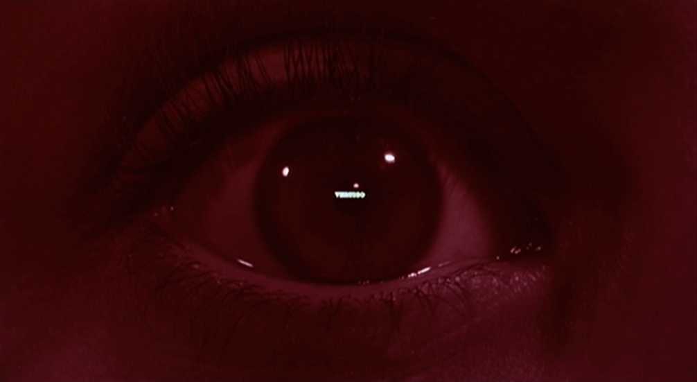 Spectatorship Theory: Film Studies Concepts and Analysis 2 Extreme close-up of a human eye tinted red, with small points of light and the word “Vertigo” visible as a reflection in the pupil.