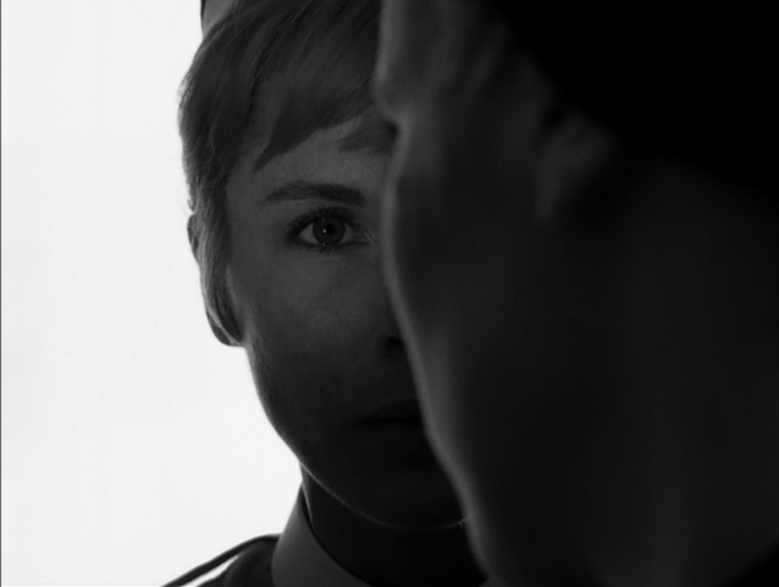 Psychoanalytic Film Theory: Definition and Key Concepts 5 Black-and-white close-up of a woman’s face with one eye visible, while another person’s face and shoulder in dark shadow cover the right half of the frame against a bright white background.